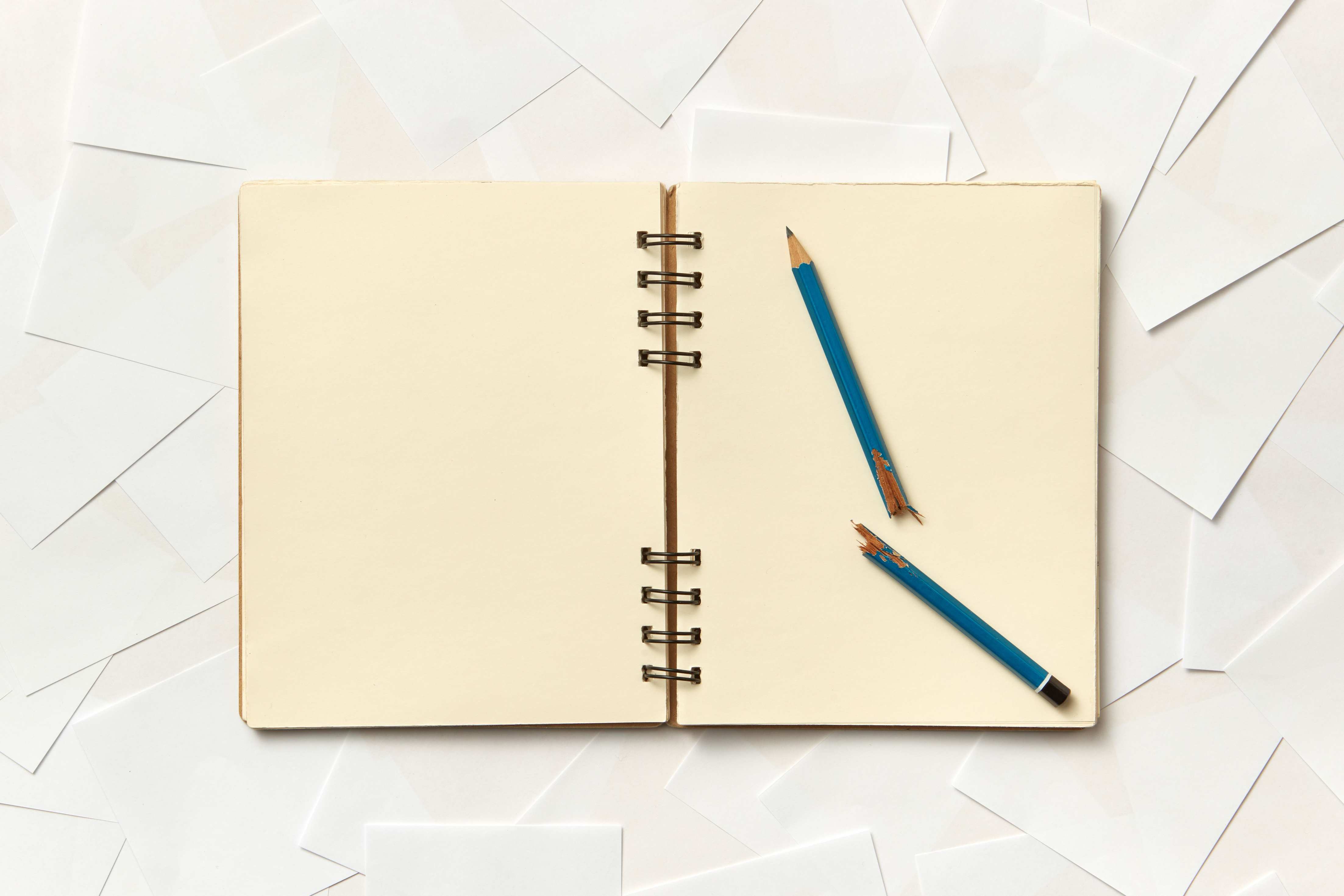 Notizblock und Stift auf Papier neben handschriftlichen Notizen